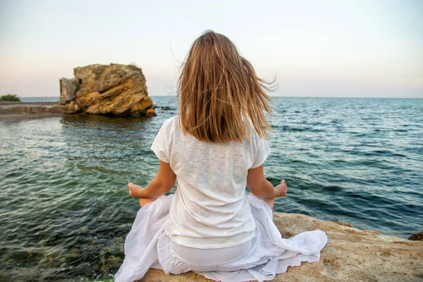 Kvinde mediterer på havet - Stock-foto