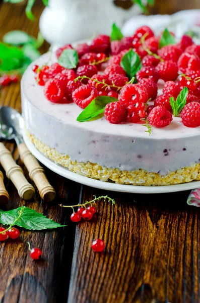 Tarta de queso con frambuesas en una mesa de madera — Foto de Stock