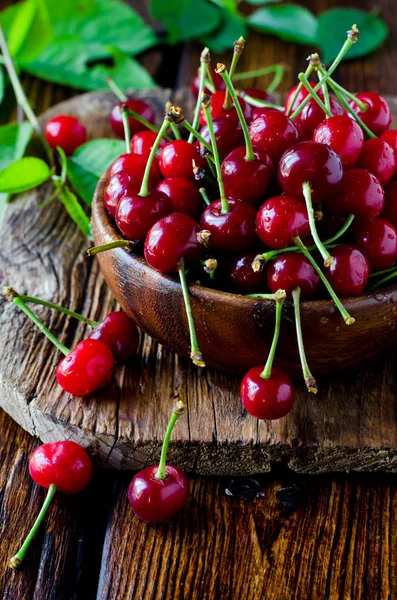 Frische Kirsche in einer hölzernen Schüssel auf einem Holztisch — Stockfoto