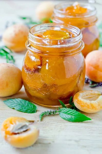 Marmellata di albicocche in un vaso su un tavolo di legno — Foto Stock