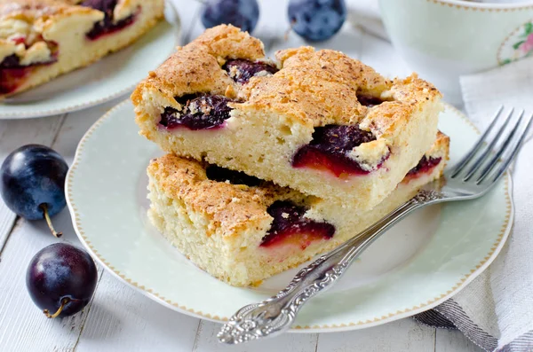 Plum cake met karamel op een witte houten tafel — Stockfoto