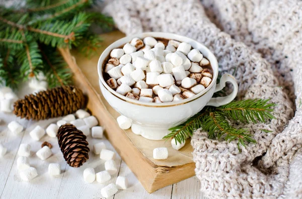 Горячий шоколад с зефиром на столе с рождественскими украшениями — стоковое фото