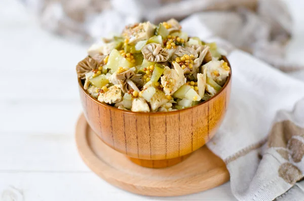 Salad of chicken, potatoes, pickled mushrooms and pickles with parchment from Dijon mustard — Stock Photo, Image