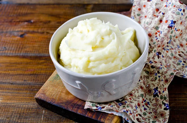 Aardappelpuree in een kom op een houten tafel — Stockfoto