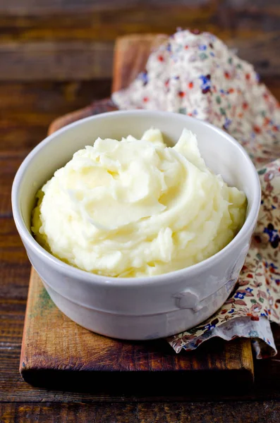 Mashed potatoes in a bowl on a wooden table — Stock Photo, Image