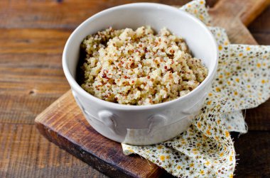Ahşap bir masa üzerinde bir kapta haşlanmış quinoa