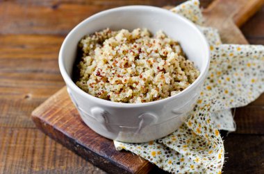 Ahşap bir masa üzerinde bir kapta haşlanmış quinoa