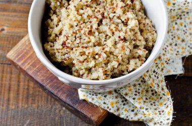 Ahşap bir masa üzerinde bir kapta haşlanmış quinoa