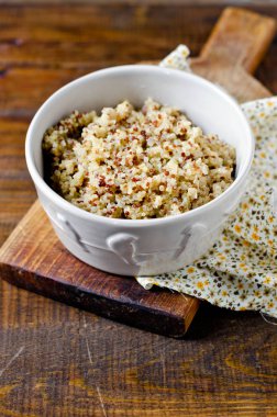 Ahşap bir masa üzerinde bir kapta haşlanmış quinoa