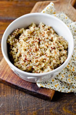 Ahşap bir masa üzerinde bir kapta haşlanmış quinoa