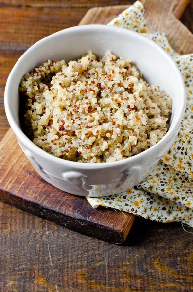 Gekookte quinoa in een kom op een houten tafel — Stockfoto