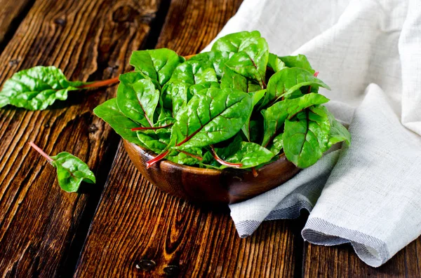 Fresh chard leaves in a wooden bowl — Stock Photo, Image