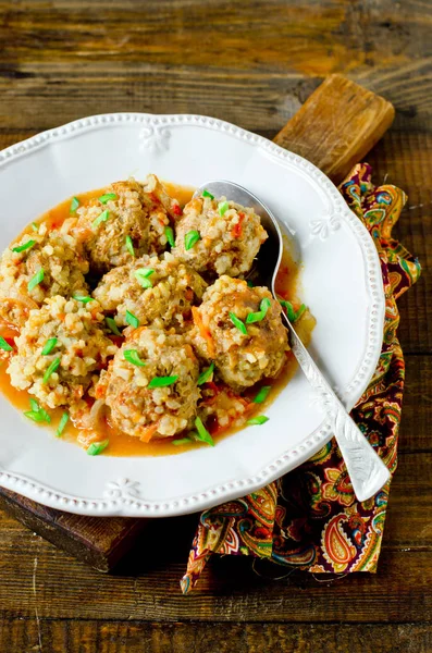 Gehaktballen met tomatensaus in een plaat op een houten tafel gestoofd — Stockfoto