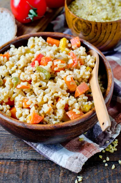 Porridge from bulgur with vegetables: carrots, bell peppers, oni — Stock Photo, Image