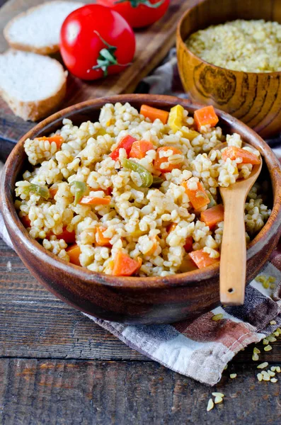 Porridge from bulgur with vegetables: carrots, bell peppers, oni — Stock Photo, Image