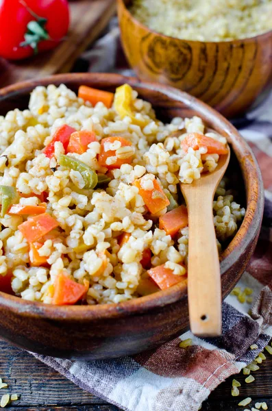 Porridge from bulgur with vegetables: carrots, bell peppers, oni — Stock Photo, Image