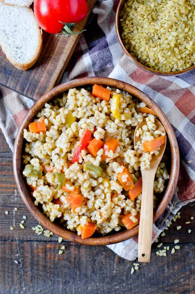 Porridge from bulgur with vegetables: carrots, bell peppers, oni — Stock Photo, Image