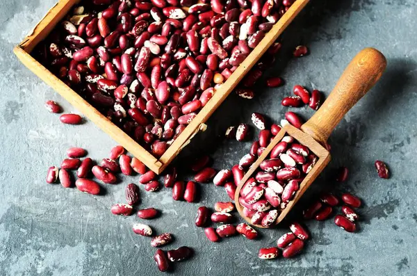 Rauwe Bonen Een Houten Bolletje Een Grijze Achtergrond — Stockfoto