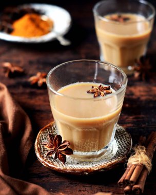 Koyu ahşap arka planda cam bardakta Masala çayı. kırsal