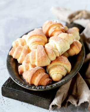 Gri arka planda metal bir tabakta süzme peynir simitleri.