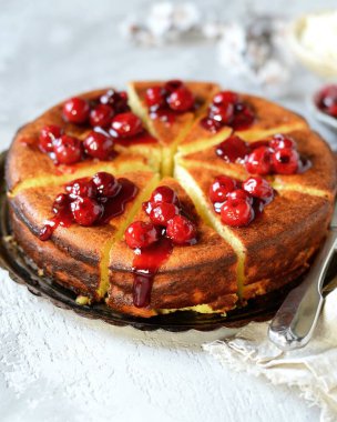 Gri arka planda kiraz soslu süzme peynir güveci.