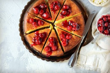 Gri arka planda kiraz soslu süzme peynir güveci.