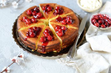 Gri arka planda kiraz soslu süzme peynir güveci.