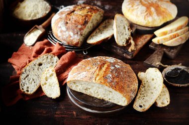 Ev yapımı ekmek: mısır, susam tohumları ve siyah ahşap arka planda chia tohumları. kırsal