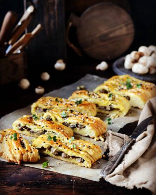 Koyu ahşap arka planda mantarlı ev yapımı maya turtası.