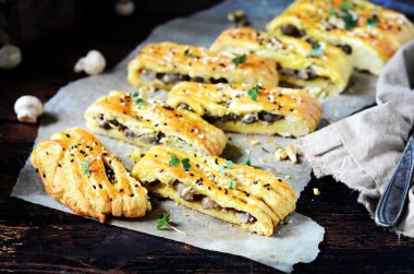 Koyu ahşap arka planda mantarlı ev yapımı maya turtası.