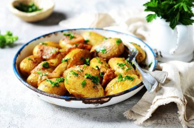 Pastırmalı, baharatlı ve otlu fırında patates. Gri bir arka planda pişirme kabında, hayat devam ediyor.