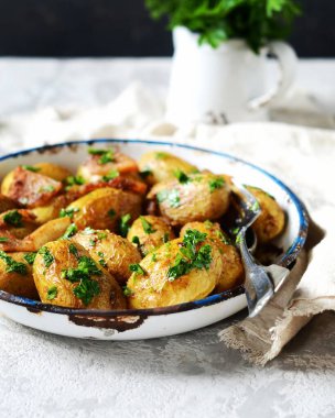 Pastırmalı, baharatlı ve otlu fırında patates. Gri bir arka planda pişirme kabında, hayat devam ediyor.