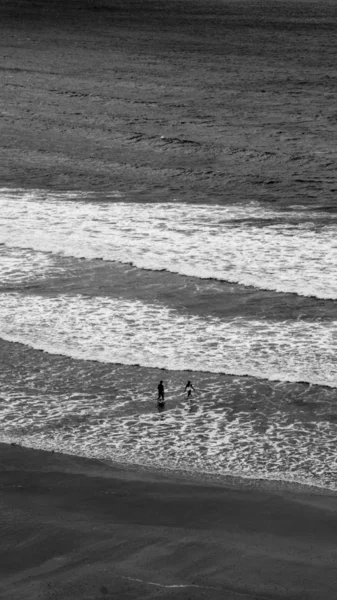 两名勇敢的游泳者在康沃尔北部的波塞斯海滩与水交谈 向汹涌的海浪中游去 — 图库照片