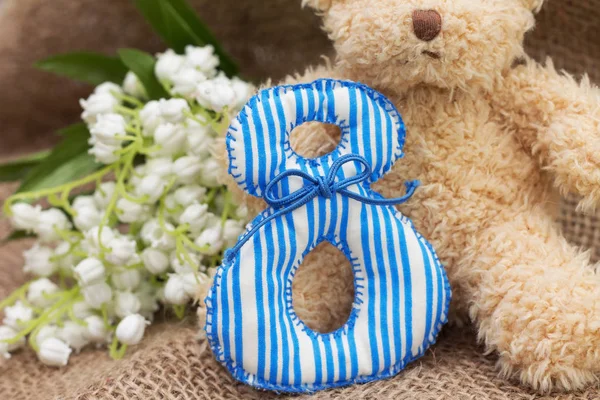 Teddybeer en mei-lily. Het cijfer 8, close-up — Stockfoto