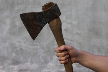 Kirli bir adamın elinde bir balta, gri arka plan üzerinde tutar.