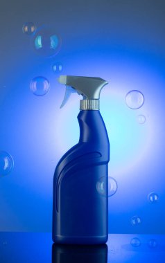 Mavi arka planda sabun köpükleriyle çevrili temizlik maddesi. Cam temizleyicisi kapat..