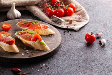 Krem peynirli taze fırça, somon balığı ve kiraz domatesli arrugula, taze sarımsak ve kurutulmuş kağıt. Bruschetta 'da deniz tuzu hareketi.