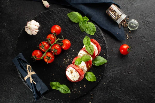 Mozzarella, taze domates, fesleğen yaprağı, sarımsak ve baharatlar, mutfak havlusuyla birlikte. Caprese salatası..