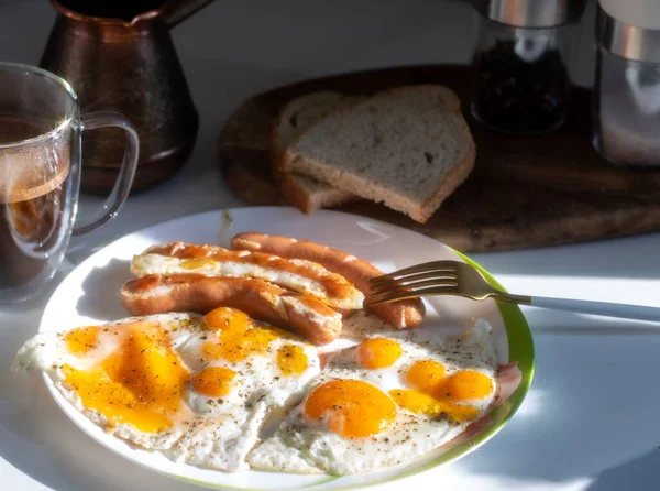 Yağda yumurta, sosis, bir fincan kahve ve bir dilim ekmek ile ev yapımı kahvaltı..
