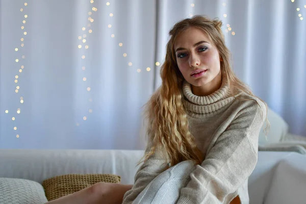 소파에 누워 있는 섹시 한 여자가 스웨터를 입고 양말을 신고 — 스톡 사진