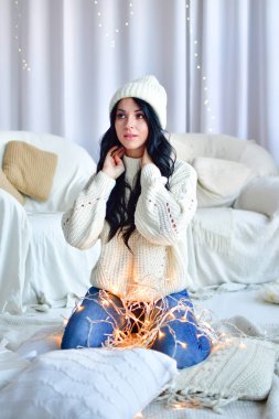 Kız Noel ağacını çelenklerle süslüyor.