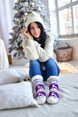 Kız Noel ağacını çelenklerle süslüyor.