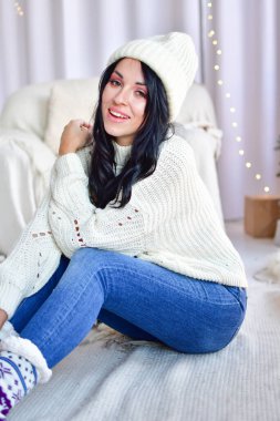 Kız Noel ağacını çelenklerle süslüyor.