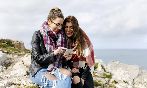 Two friendly women using her smartphone