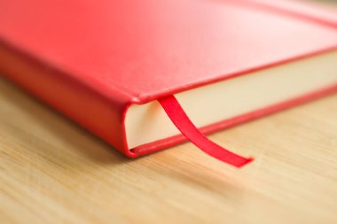 Ahşap masaya yakın plan kırmızı çizim defteri. Resim, çizim ve yazma için şık bir defter.