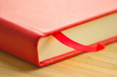 Ahşap masaya yakın plan kırmızı çizim defteri. Resim, çizim ve yazma için şık bir defter.