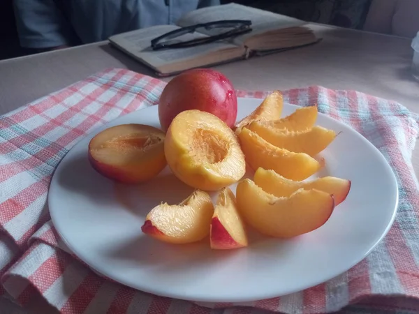 Masanın üzerinde nektarin parçaları var.