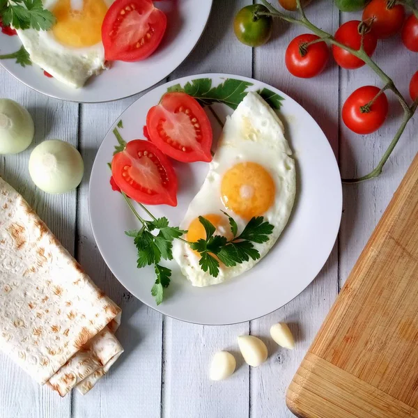 Maydanozla süslenmiş taze domatesli sahanda yumurtadan lezzetli bir kahvaltı.
