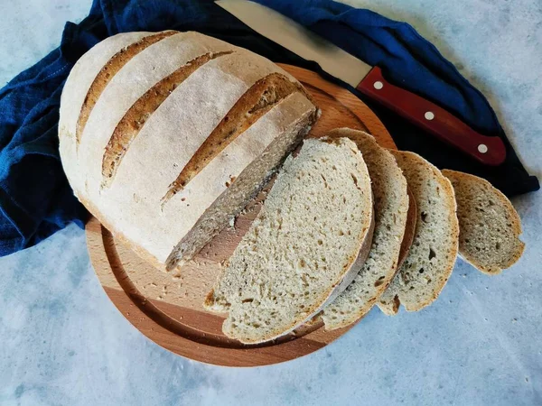 Домашній житній хліб з кислотою, нарізаним на шматки, лежить на дерев'яній дошці — стокове фото