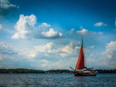 Groningen, Hollanda yakınındaki kırmızı yelken ile yelkenli yat